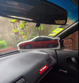 Ambientador con forma de carro deportivo colgado del espejo retrovisor